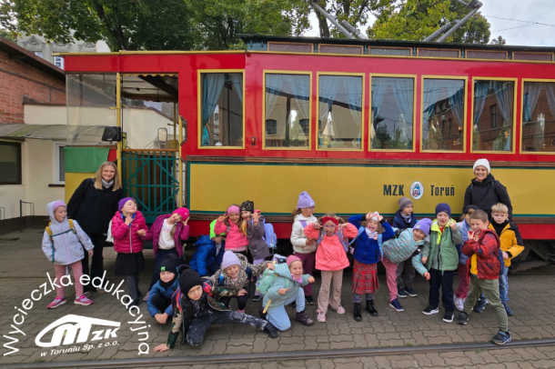 zdjęcie przedszkolaków w zajezdni tramwajowej MZK w Toruniu na tle tramwaju turystycznego